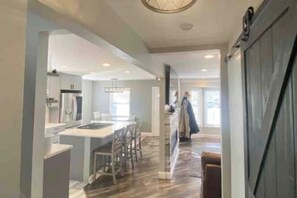 Una cocina moderna con una isla central, un comedor y vistas al salón.