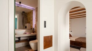 Un baño con un lavamanos grande, inodoro y zona de ducha.