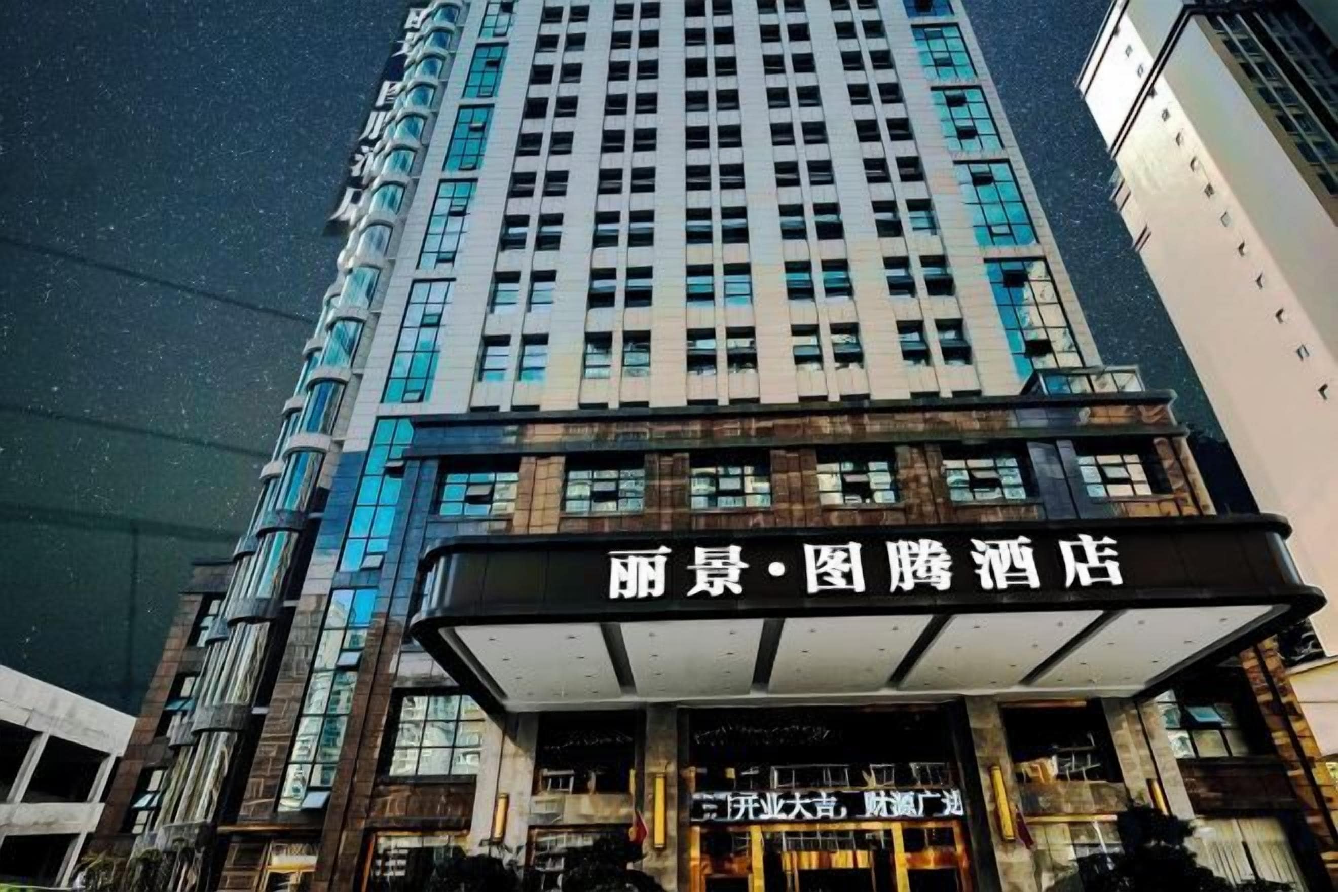 A hotel with a modern facade, featuring a prominent entrance with signage.