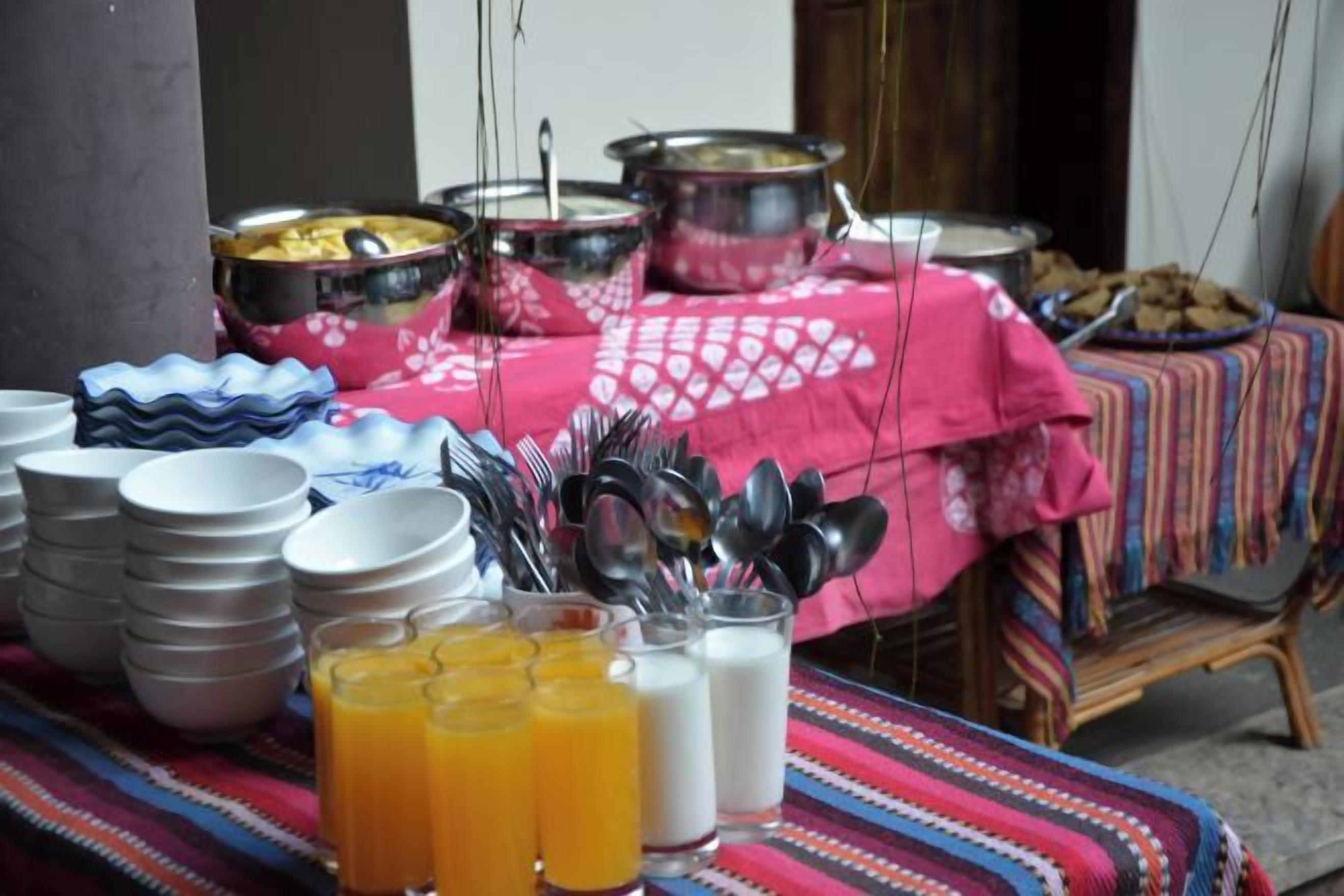 A buffet table with various dishes, bowls, and utensils.