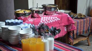 A buffet table with various dishes, bowls, and utensils.