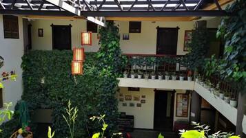 A multi-level atrium with a staircase, potted plants, and hanging lanterns.