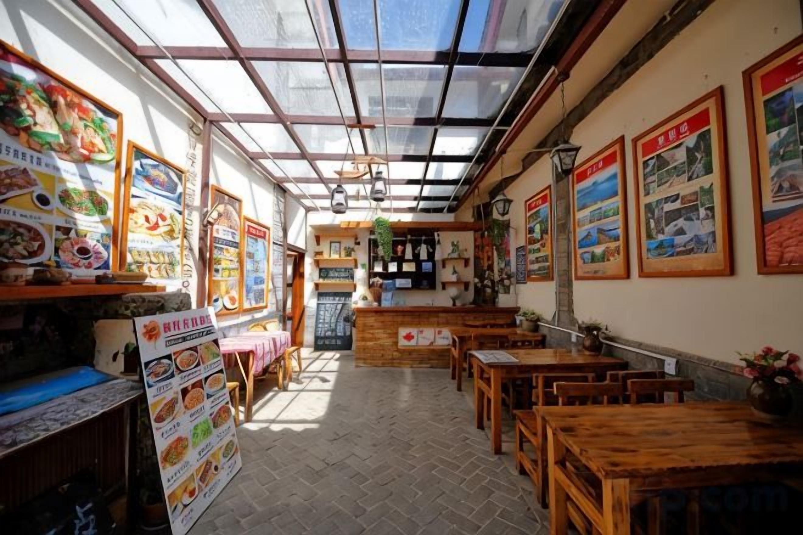 Un restaurante con techo alto, mesas y sillas de madera, y un cartel de menú a la izquierda.