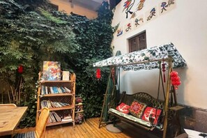A room with a bookshelf, a swing, and a wall with Chinese characters. - Maple Leaf Inn Lijiang (Lijiang)
