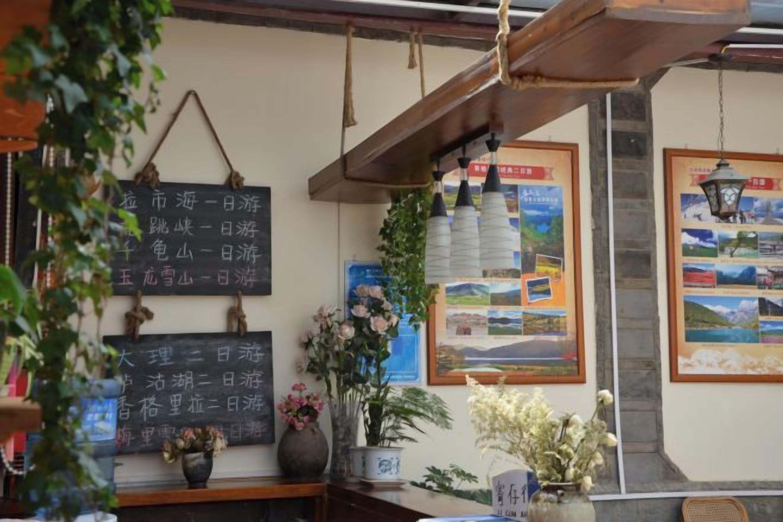 A traditional interior with a wooden ceiling, a chalkboard with travel information, and framed pictures on the wall.