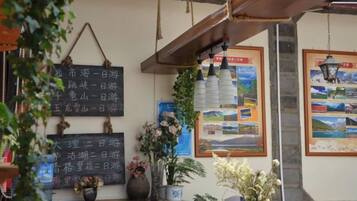 A traditional interior with a wooden ceiling, a chalkboard with travel information, and framed pictures on the wall.