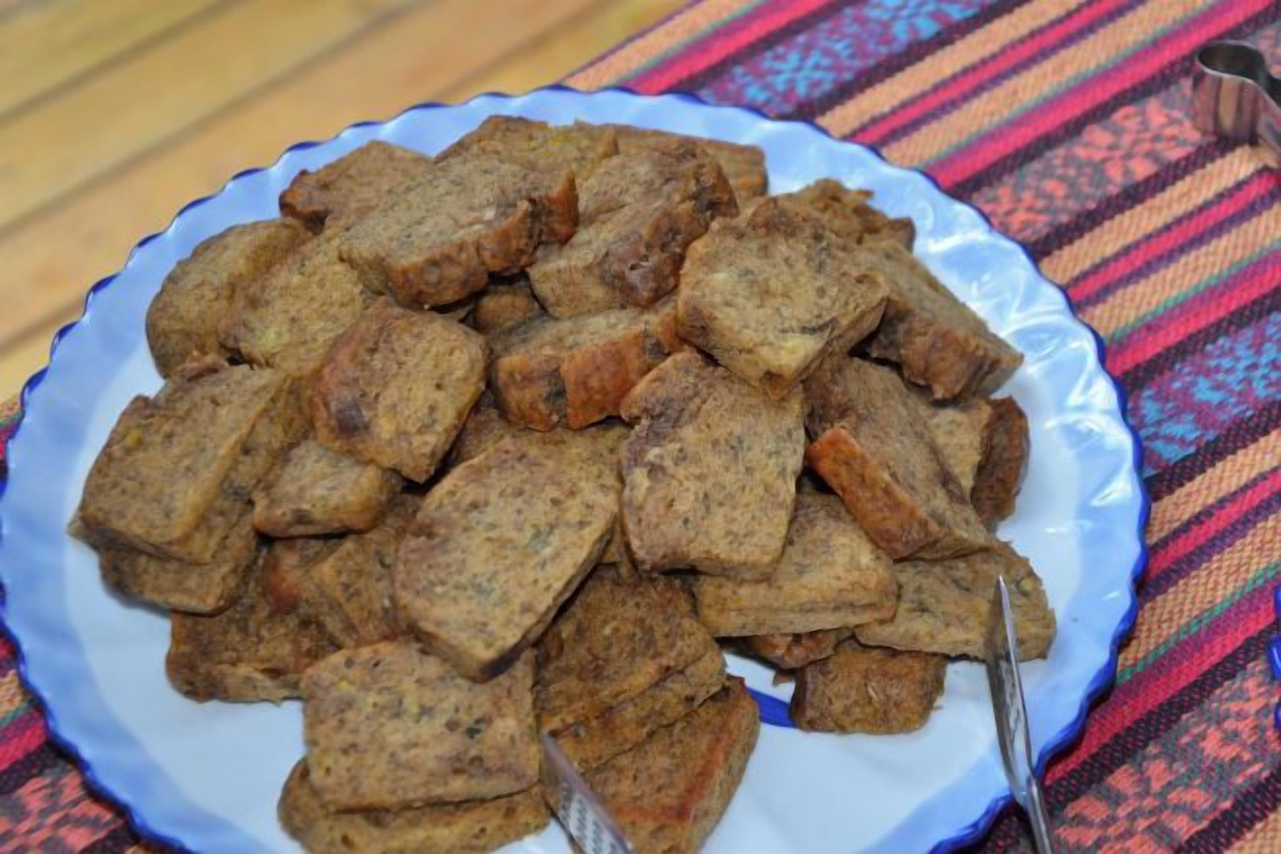 A plate of food on a table with a patterned tablecloth.