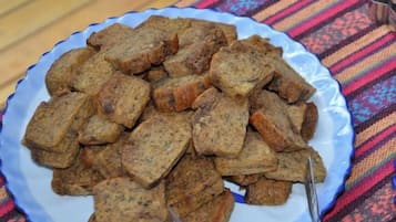 A plate of food on a table with a patterned tablecloth.