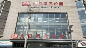 A hotel with a large glass facade and signage in both Chinese and English. - Kunshan Youjia Jitian Apartment (Kunshan South Station) (Kunshan)