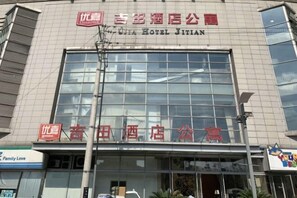 Ein Hotel mit einer großen Glasfassade und Beschilderung in Chinesisch und Englisch.