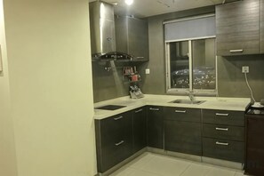 Una cocina con armarios oscuros, un ventanal y vistas a la ciudad.