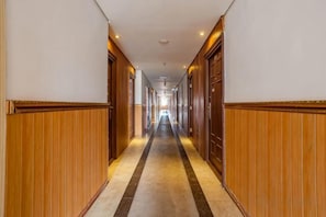 A long, narrow hallway with wooden paneling on the walls and a striped carpet. - Kunshan Youjia Jitian Apartment (Kunshan South Station) (Kunshan)