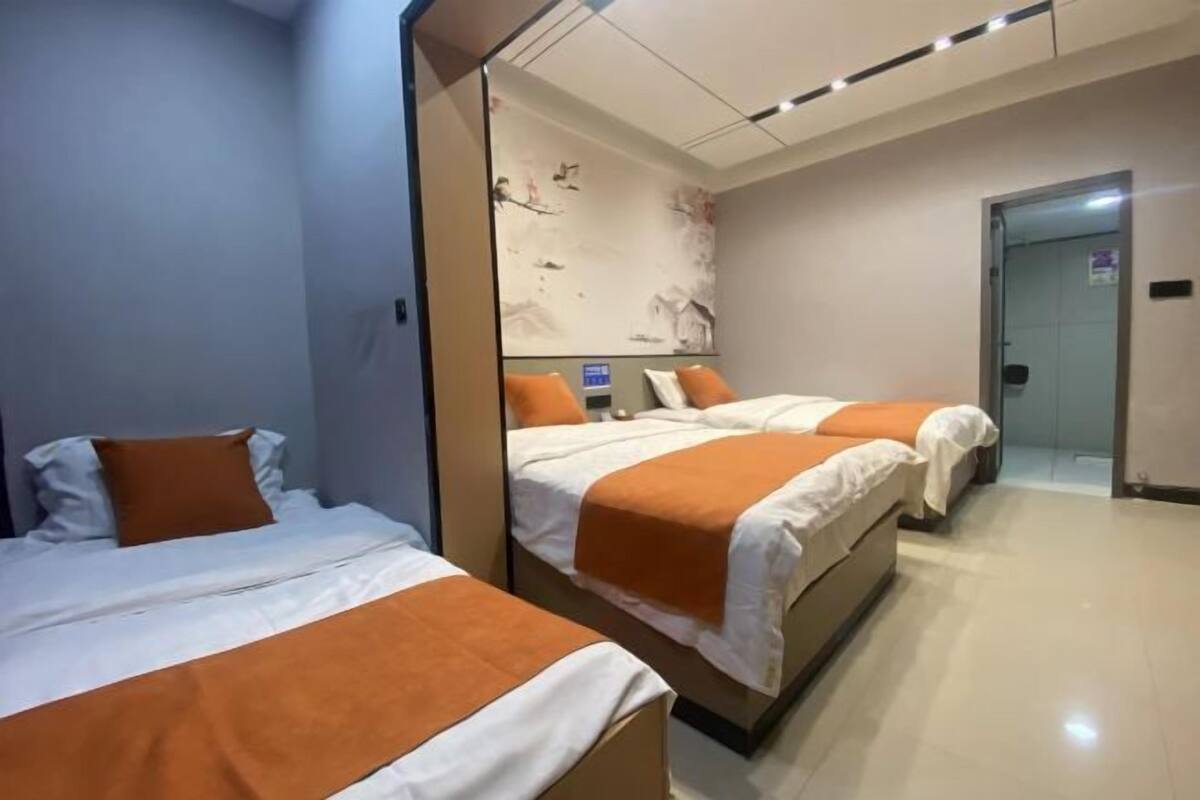 A hotel room with two beds, a large mirror, and a door leading to a bathroom.