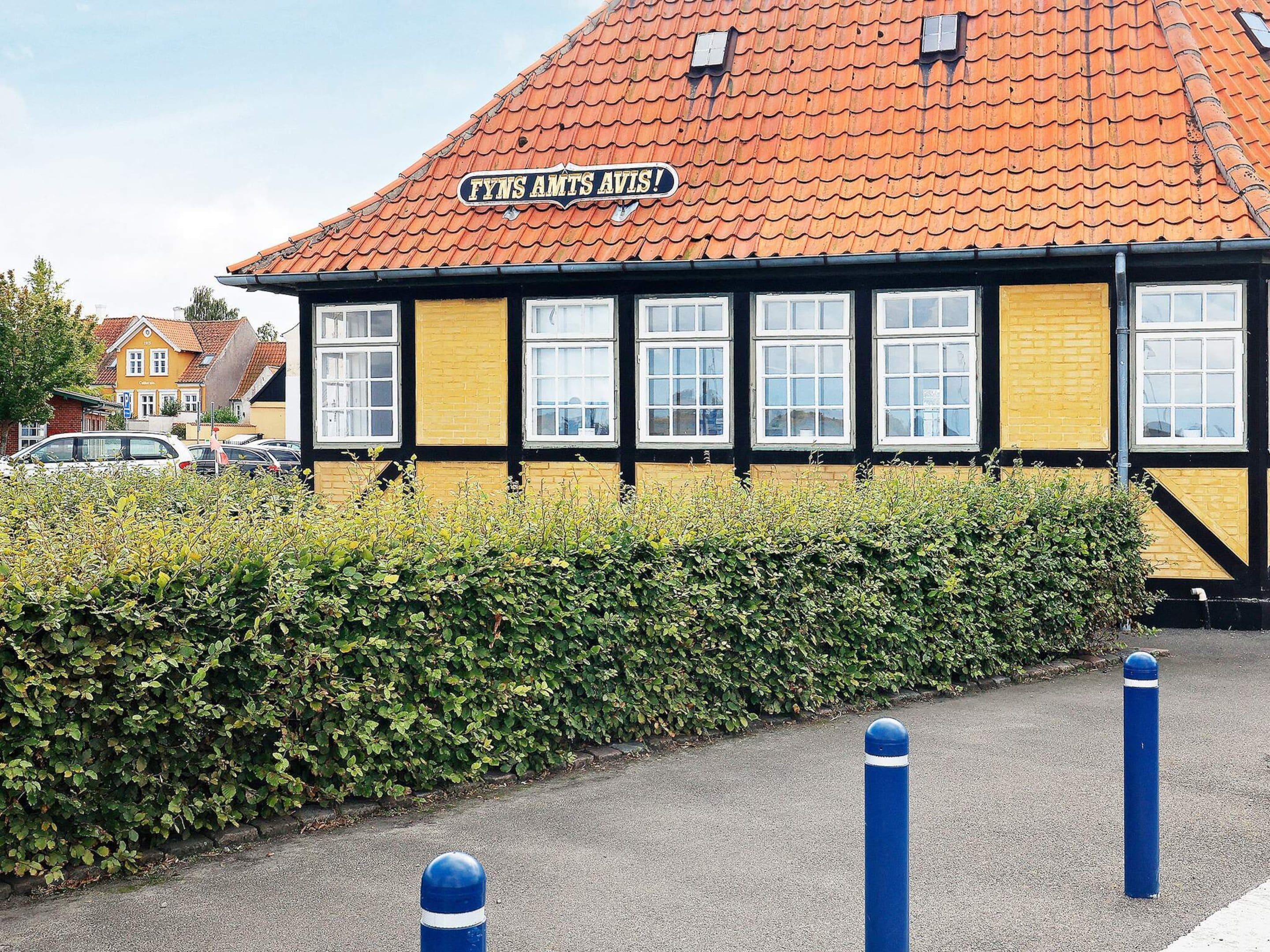 A building with a sign reading 'FYNS AMTS AVIS' and a red-tiled roof.
