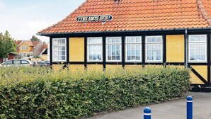 Een gebouw met een bord waarop 'FYNS AMTS AVIS' staat en een dak met rode tegels.