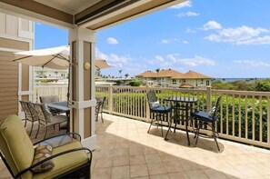 Relax in a serene ocean-view setting with two seating areas, a shaded umbrella, and a tranquil atmosphere.