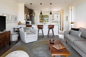 Relax in this inviting space with a comfortable sofa, wooden coffee table, and large window offering a view.