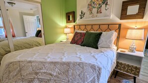 A well-lit bedroom with a large bed, green walls, and a decorative elephant painting. - Extended Stay! 2 Bedroom/1 bath/Sleeps 6 (Vista)