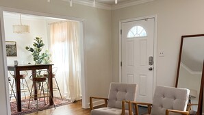 A living room with a wooden coffee table, two armchairs, a sofa, and a chandelier. - High Point House - amazing location -Sleeps 12! (Memphis)