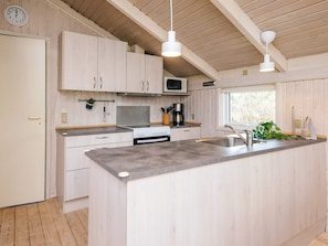 A modern kitchen with wooden cabinets, a central island, stainless steel appliances, and pendant lighting. - 6 Person Holiday Home in Ulfborg (Ulfborg)
