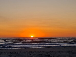 A sunset over the ocean with waves. - 6 Person Holiday Home in Ulfborg (Ulfborg)