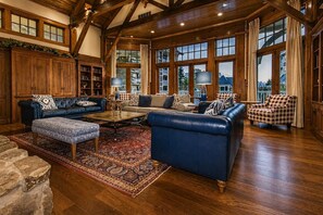 A spacious living room with leather sofas, a coffee table, and a large window with curtains. - AS 111 - Summer Comfort with a View & Pool Facing Village Escape (Snowshoe)