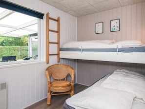 A room with a bunk bed, a rattan chair, a window with blinds, and two framed pictures on the wall. - 6 Person Holiday Home in Tarm (Tarm)