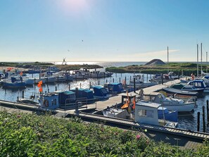 A marina with multiple boats docked, a clear sky, and a distant hill. - 6 Person Holiday Home in Tarm (Tarm)