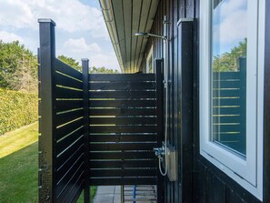A black metal gate leading to a building with a window and a hose attached to the wall. - 6 Person Holiday Home in Tarm (Tarm)