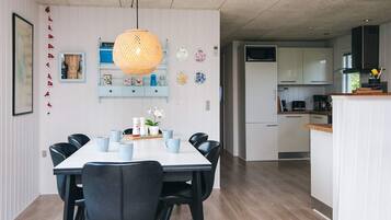 Una cocina moderna con armarios blancos, microondas y cafetera.