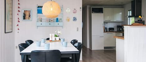 A modern kitchen with white cabinets, a microwave, and a coffee maker.
