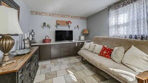 A compact living space with a sofa, television, and kitchen area.