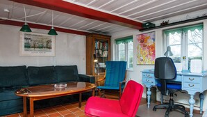 A room with a wooden table, a red chair, a blue chair, a blue desk, and a green pendant light. - 6 Person Holiday Home in Augustenborg (Augustenborg)