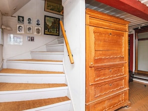 A staircase with a wooden cabinet on the right. - 6 Person Holiday Home in Augustenborg (Augustenborg)