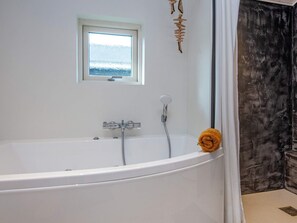 A modern bathroom with a freestanding bathtub, a window, and a showerhead. - 4 Star Holiday Home in Ebeltoft (Ebeltoft)