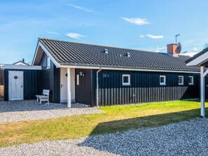 A single-story building with a dark exterior, a sloped roof, and a small porch area. - 6 Person Holiday Home in Ebeltoft (Ebeltoft)
