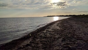 Ein Strand mit breitem Sandstrand und ruhigem Wasser.