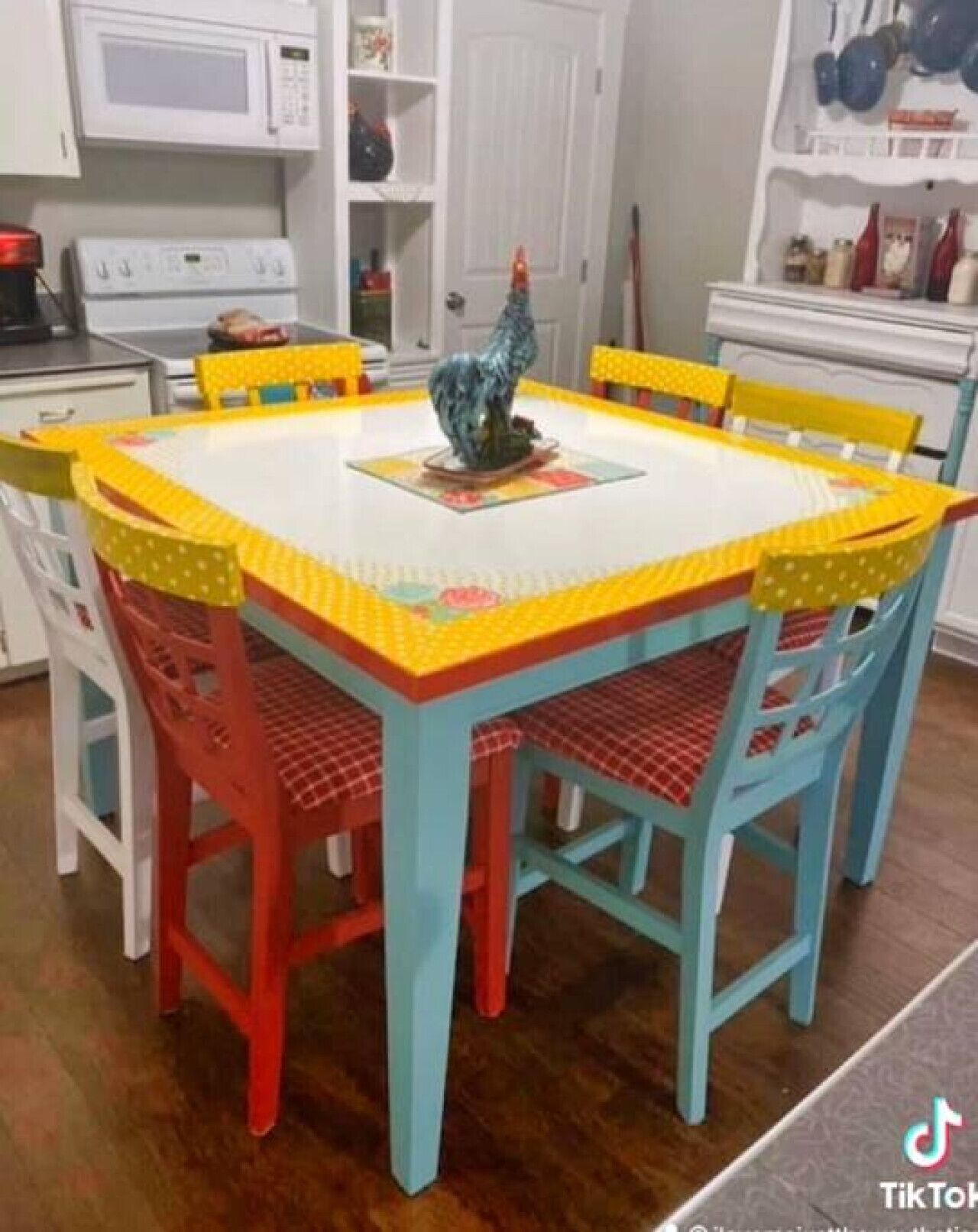 A dining area with a square table and four chairs, each with a different color.