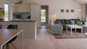 A modern kitchen with a dining area, a sofa set, and a view of the outdoors. - 6 Person Holiday Home in Hojby-by Traum (Hojby)