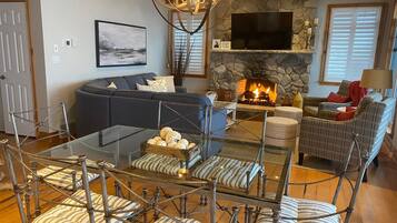 Smart TV, lareira, livros, videoteca