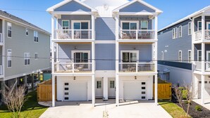 A multi-story residential building with a central staircase, balconies, and attached garages. - Pearl Paradise: with elevator & golf cart included! 2 blocks to beach.  (Carolina Beach)