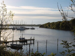 A calm river with boats docked at a pier, surrounded by trees. - 5 Star Holiday Home in Nordborg (Nordborg)