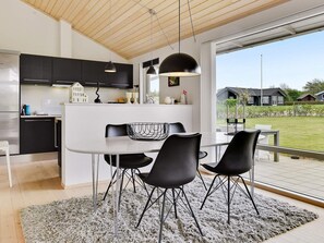 Una cocina moderna con comedor, que cuenta con un amplio ventanal y vistas al exterior.