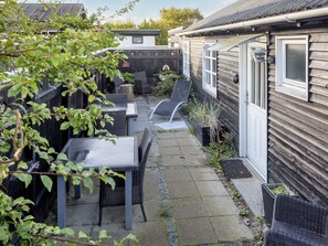 A patio area with outdoor furniture, a small garden, and a wooden house. - 4 Star Holiday Home in Skagen (Skagen)