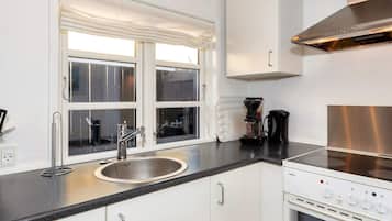 A modern kitchen with a stainless steel sink, a coffee maker, and a built-in oven.