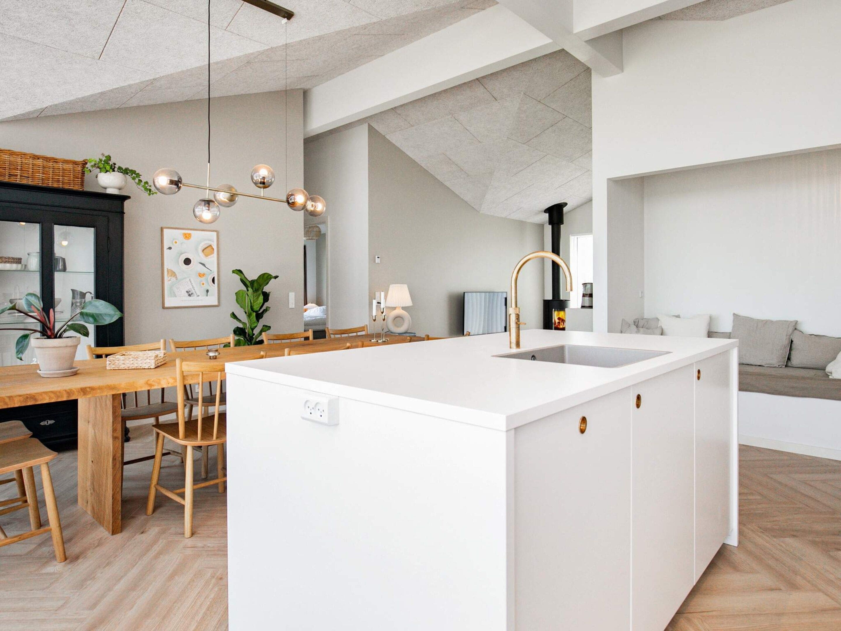 Una cocina moderna con una isla central, una mesa de comedor de madera y sillas.