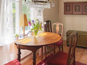A dining room with a wooden table, chairs, a chandelier, and a cabinet. - 9 Person Holiday Home in Ronneby (Listerby)