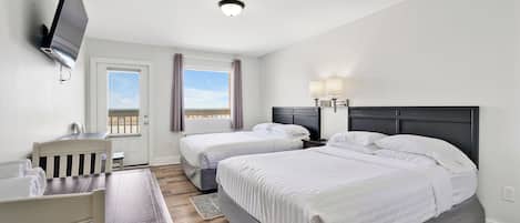 Habitació d'hotel amb dos llits, una taula de treball, un televisor fixat a la paret i una finestra amb cortines.