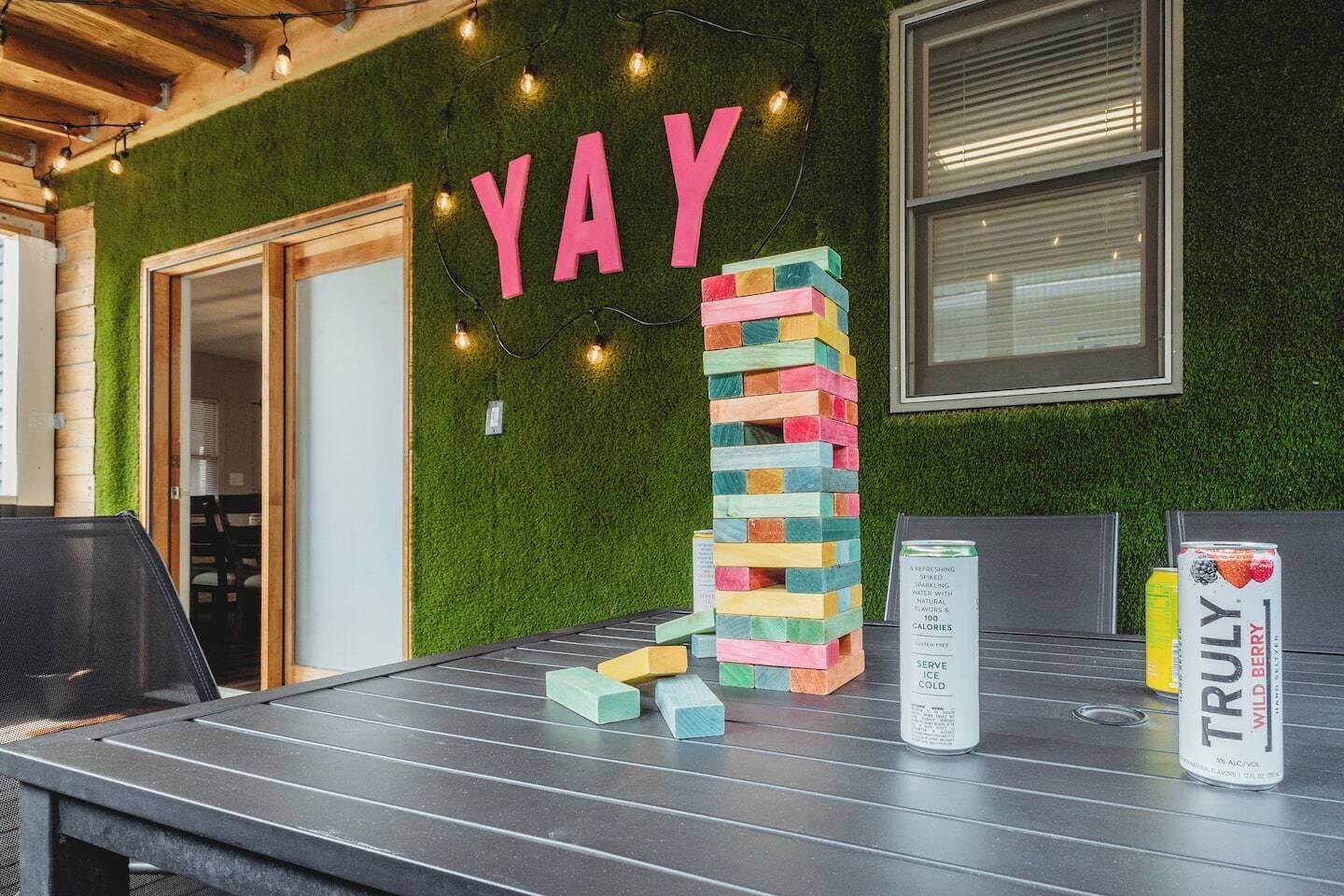 Une table avec une pile de blocs de couleurs vives, une pancarte sur laquelle on peut lire « HOURRA » et une boîte de glace à la saveur de fruits des bois « Truly Wild Berry ».