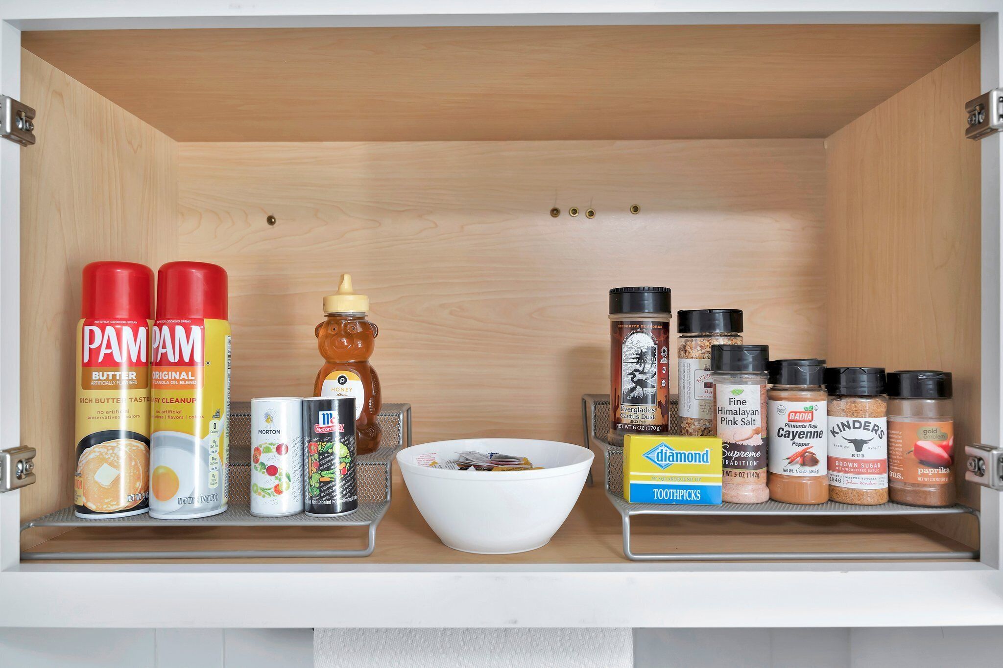 A kitchen cabinet with various food items and condiments.